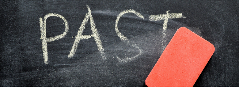 An orange eraser erases the word past on a chalkboard